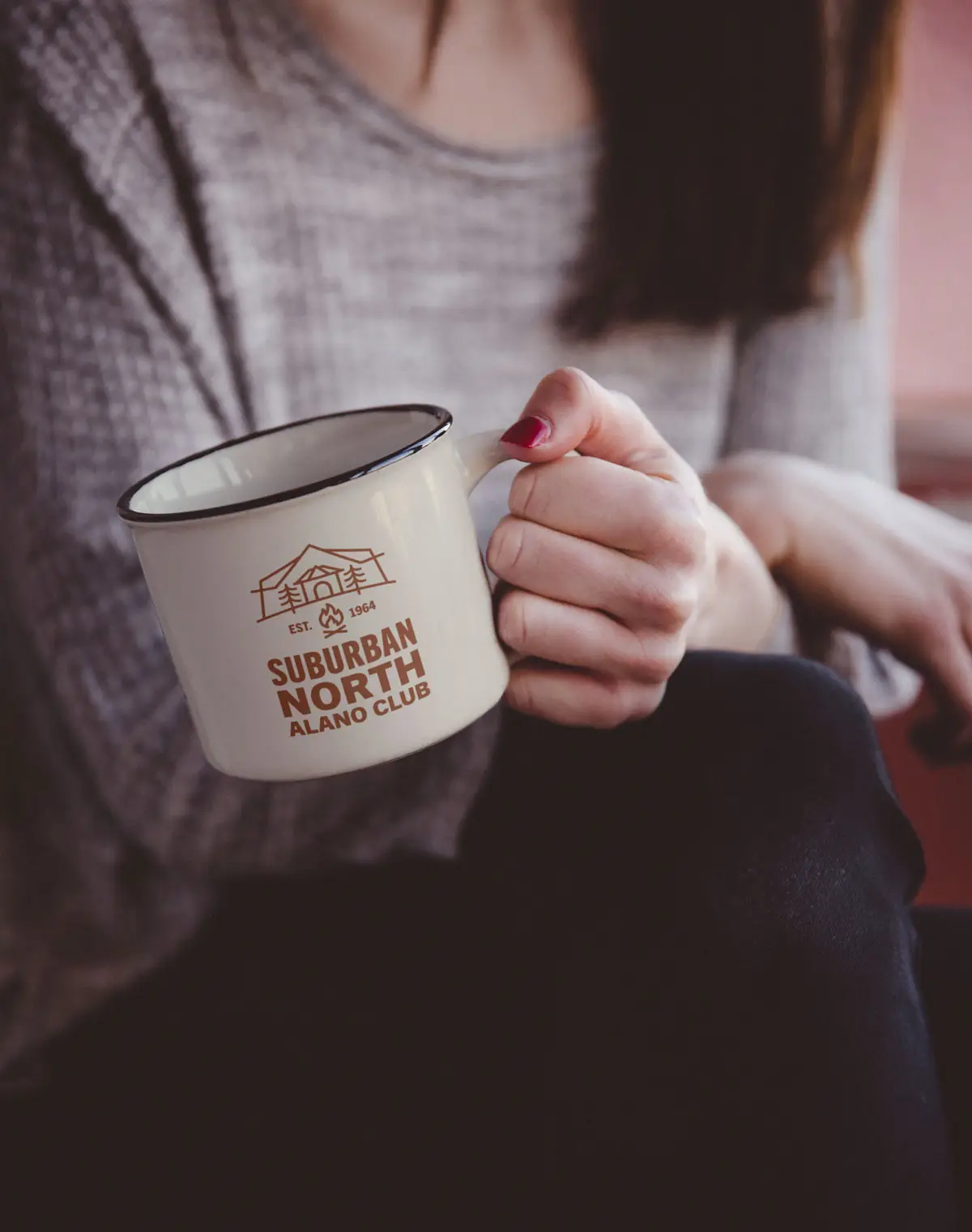 Hand-Holding-Metal-Mug coffee mug with rust-orange logo